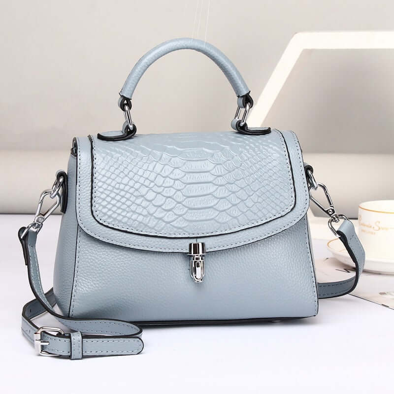 Real leather crossbody bag in trendy blue with crocodile print and stylish handle.