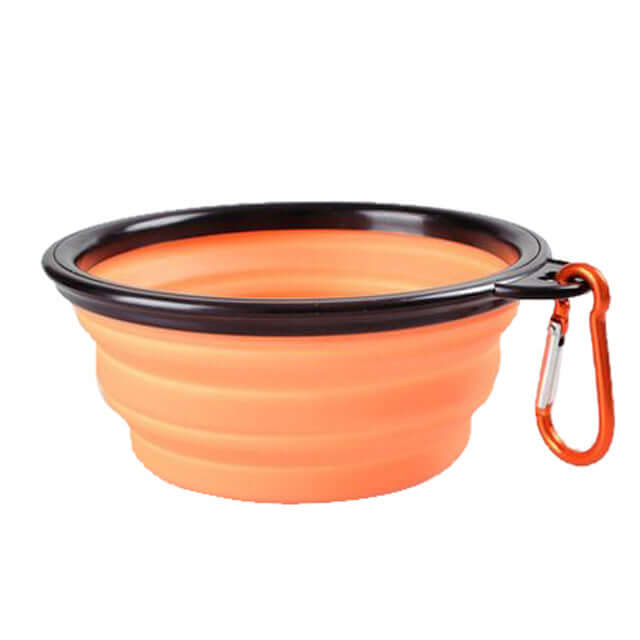 Collapsible pet bowl in orange silicone with a black rim and carabiner for easy on-the-go feeding.