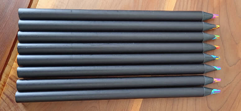 Black Wooden Colored Pencil Set for Drawing displayed with vibrant color tips on a wooden surface.