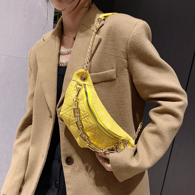 Woman wearing a stylish yellow diamond chain crossbody bag with a chic design.