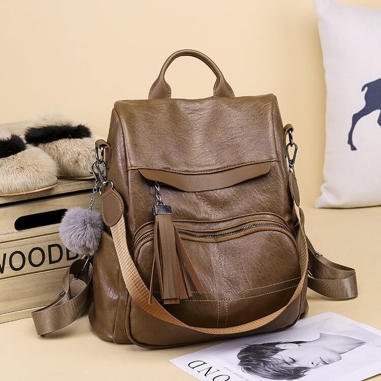 Retro Style Women's Large Capacity Fashion Backpack in brown PU leather with tassel and pom pom keychain.