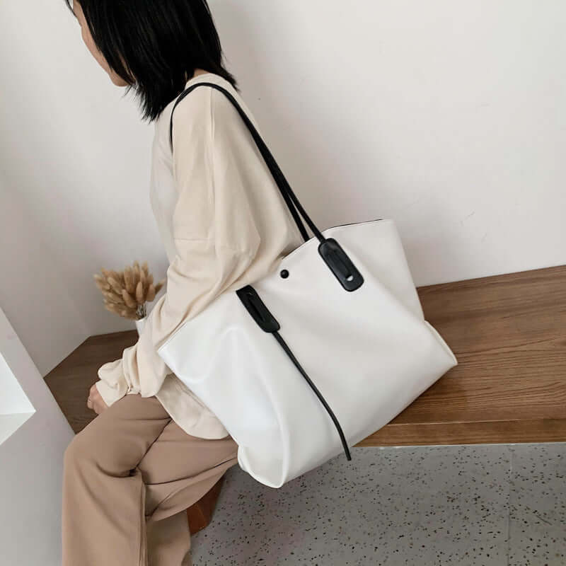 Stylish woman carrying a women's one shoulder handbag in white, showcasing modern fashion and functionality.