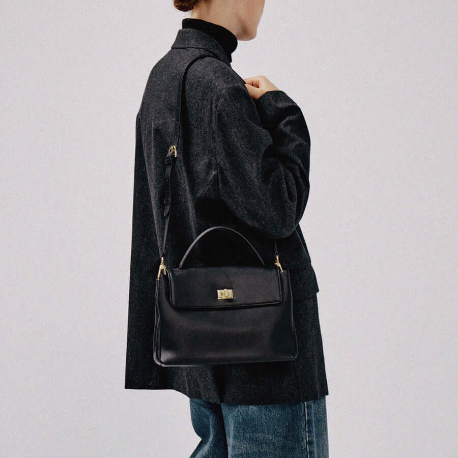 Large capacity cowhide crossbody bag styled with a chic outfit, showcasing its elegance and versatility.