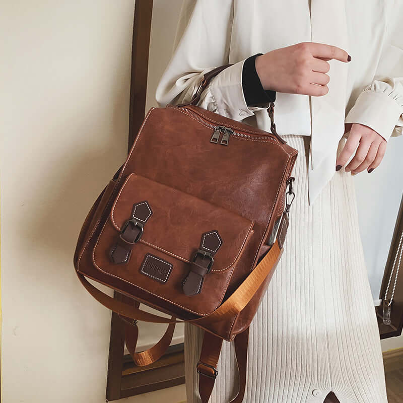 Trendy Vintage PU Leather Women's Backpack for Travel held by a woman in casual attire.