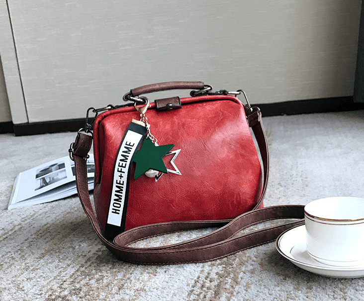 Stylish Doctor's Bag, Shoulder Bag, Crossbody Bag in red with unique keychain accent on a table setting.