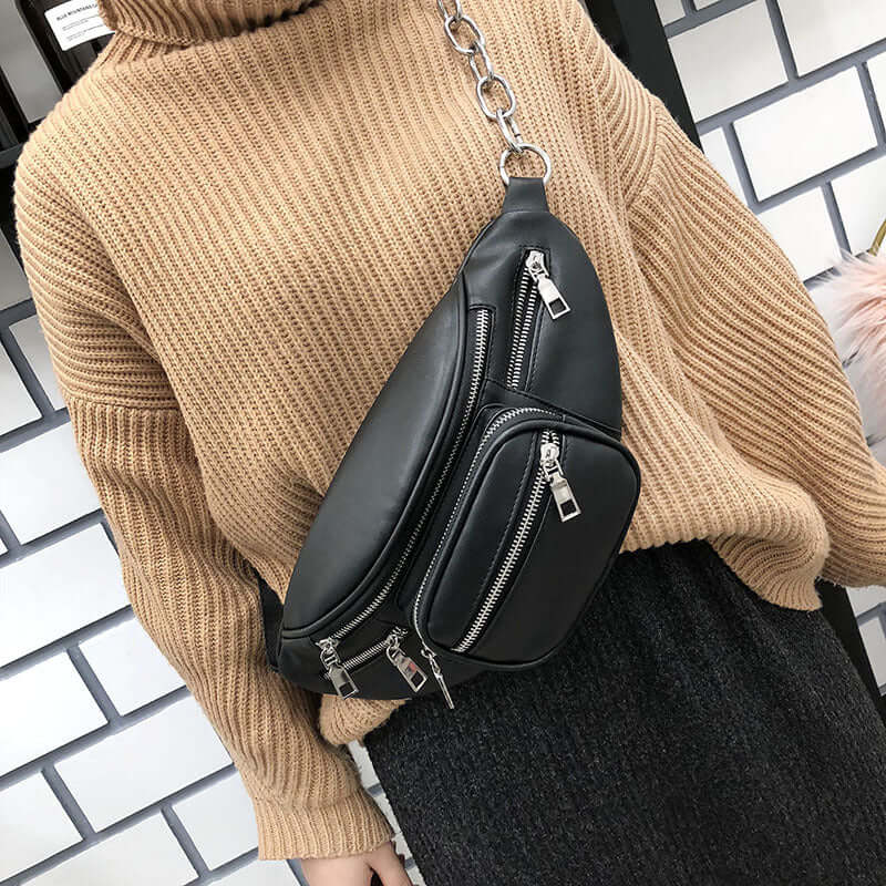 Stylish crossbody phone bag worn with a cozy sweater, featuring multiple zippered pockets for practicality.