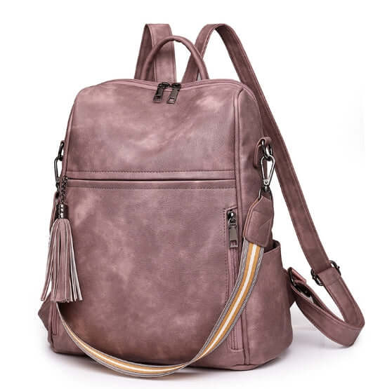 Fashionable anti-theft travel backpack in mauve with stylish tassel and adjustable straps.