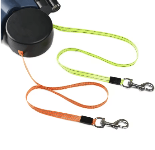 Automatic double dog leash with retractable dual lines in orange and green for walking two dogs.