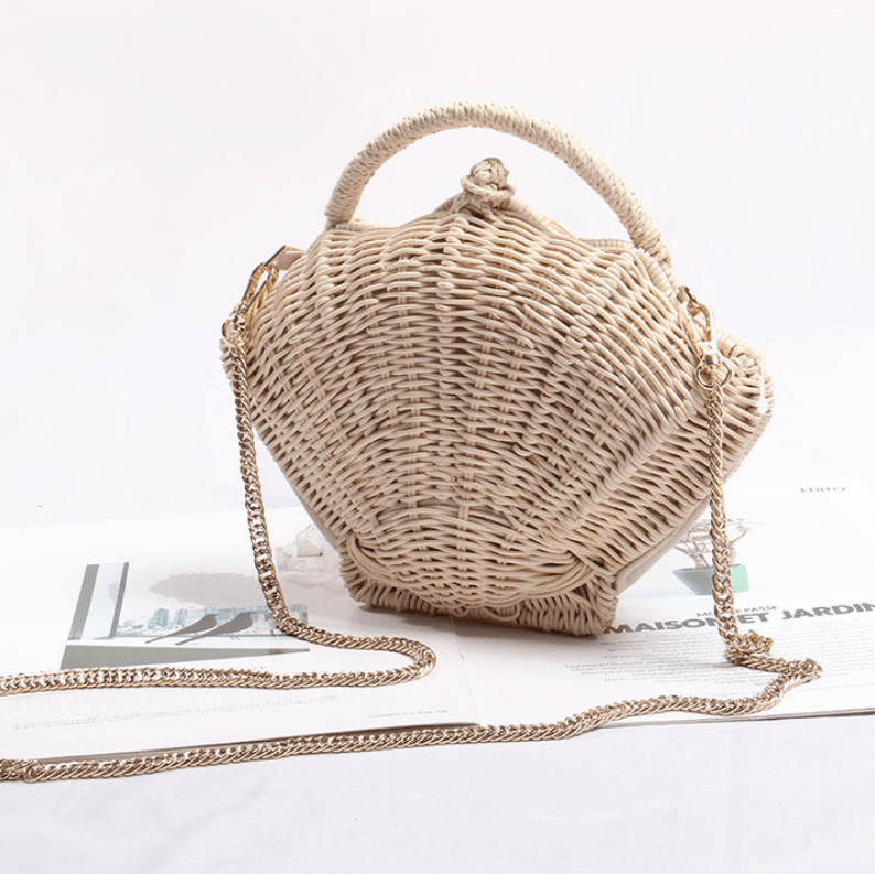 Stunning woven straw beach bag with chain, showcasing a unique shell design and durable straw weaving.