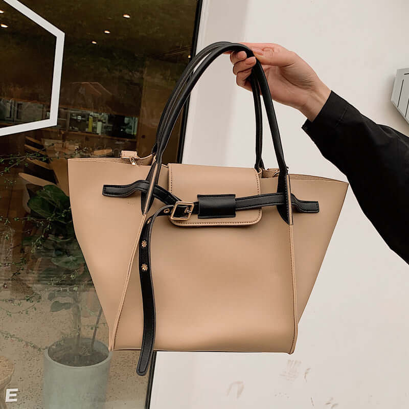 Chic crossbody shoulder bag held by a hand, showcasing a stylish two-tone design and quality craftsmanship.