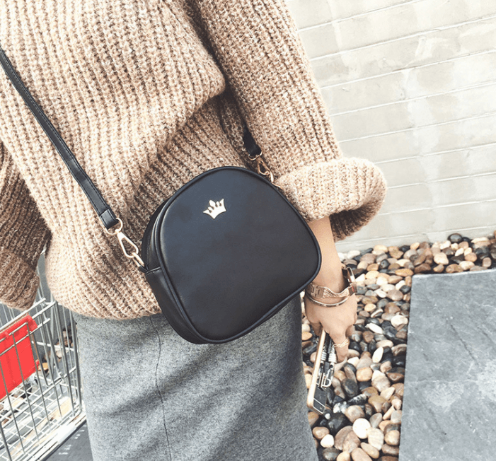 Chic crossbody shoulder bag worn casually with a cozy sweater, highlighting its stylish design and compact size.
