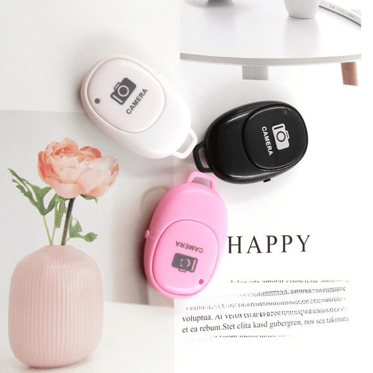 Wireless Bluetooth selfie remote for Android iOS in black, white, and pink colors.