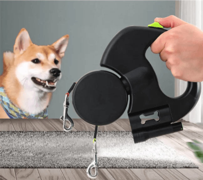 Auto Double Dog Leash in use with a user holding the retractable handle and a dog looking on.