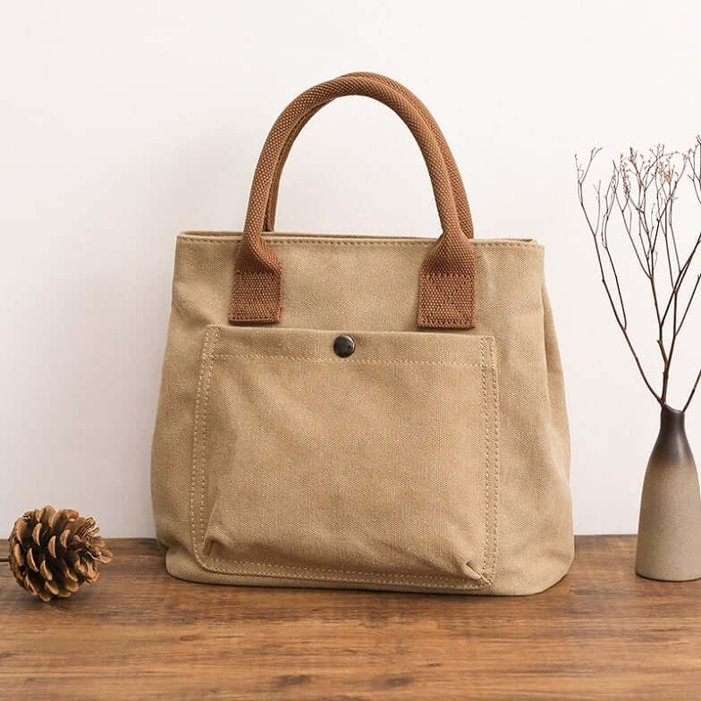 Japanese Korean fashion handbag in a stylish canvas design with sturdy handles and front pocket.